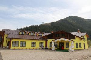 a yellow building with an arch in front of it at Ресторан-Готель Міжгірʼя in Usteriki