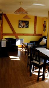 uma sala de estar com uma mesa e cadeiras e um sofá em Les 3 Ceps em Bergholtz