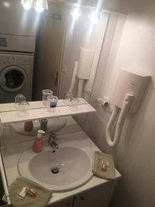 een badkamer met een wastafel en een wasmachine bij Barnetche in Villefranque