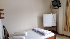 una camera da letto con un letto e una TV in una stanza di Hotel Ximenes a Casimiro de Abreu