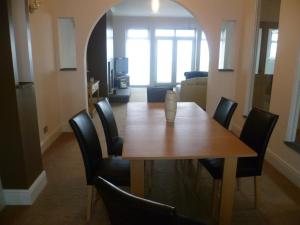 a dining room with a wooden table and black chairs at The Beach House in Thurso