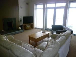 a living room with a white couch and a table at The Beach House in Thurso