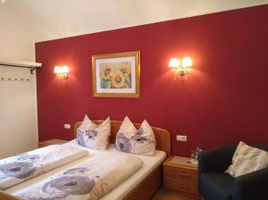 1 Schlafzimmer mit 2 Betten und einer roten Wand in der Unterkunft Gästezimmer Brühl in Markt Sankt Florian