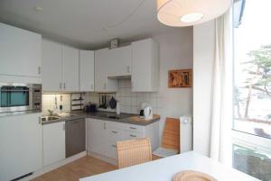 eine Küche mit weißen Schränken und einem großen Fenster in der Unterkunft Villa Strandperle, Whg. 10 in Bansin