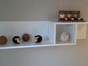 a white shelf with balls on the wall at BUE - Ferienhaus Helmcke in Büsum