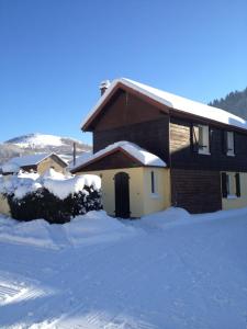 a house with snow on the ground in front of it at Gîtes Les Grandes Voies - Clé Vacances in Le Ménil