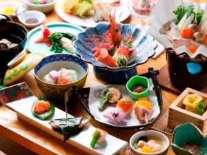a wooden table with plates of food on it at Karurusu Onsen Yumoto Orofuresou in Noboribetsu