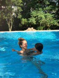 una mujer y un niño en una piscina en Hospedagem Fazenda Nova América en Brotas
