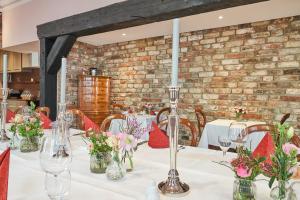 a dining room with tables with flowers in vases at TOP CityLine Klassik Altstadt Hotel Lübeck in Lübeck