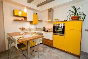 a kitchen with yellow cabinets and a wooden table at Gite urbain AU 2BIS - Annecy in Annecy