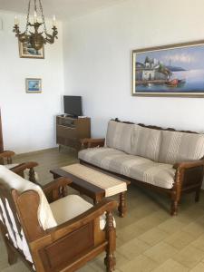 a living room with a couch and a table at Lefkada Beachfront Apartment in Nikiana