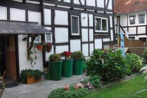 a house with green trash cans in front of it at Ferienwohnung Misch in Eschwege