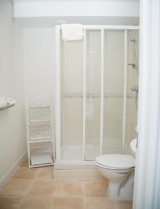 a white bathroom with a shower and a toilet at Luxuriant Apartments in Northampton +8 photos