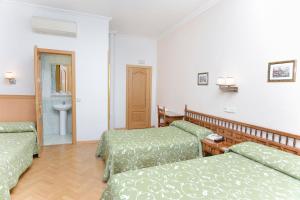 En eller flere senge i et værelse på Hostal Biarritz