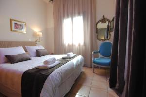 a hotel room with a bed and a blue chair at La C Mer in Larnaca