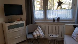 a living room with a tv and a chair and a window at Ferienwohnung Veit in Essen