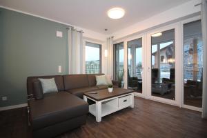 a living room with a couch and a table at Wohnen am Yachthafen W25 in Cuxhaven