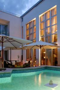 a swimming pool with two umbrellas next to a building at Villa Andrea in Pula