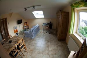 sala de estar con sofá, escritorio y ventana en FeWo-Schwarzer, en Ingelheim am Rhein
