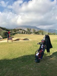 een golfer staat op een bankje op een golfbaan bij Estepona valle romano in Estepona