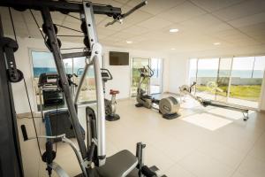 a gym with treadmills and machines in a room at Hotel De La Pyramide in Mèze
