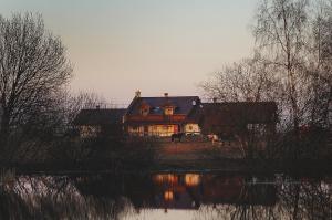 una casa con un cavallo di fronte a un lago di Gospodarstwo Agroturystyczne Milejewko a Milejewo