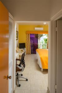 a bedroom with a bed and a desk and a chair at Bird Rock Beach Hotel in Basseterre