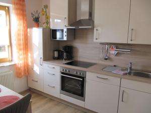 a kitchen with white cabinets and a stove and a sink at Ferienwohnung Abendstille mit Balkon und TG in Bamberg