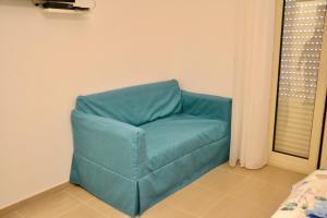 una sedia blu nell'angolo di una stanza di Hotel Caudullo a Letoianni