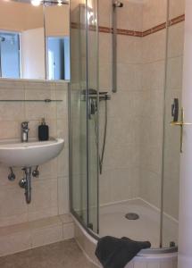 een badkamer met een douche en een wastafel bij Ferienwohnung Jolle in Bremerhaven
