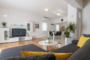 a living room with a couch and a tv at Apartmani Ville Vengo in Trogir