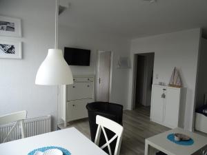 ein Wohnzimmer mit einem Tisch und einem Esszimmer in der Unterkunft Ferienwohnung Jolle in Bremerhaven