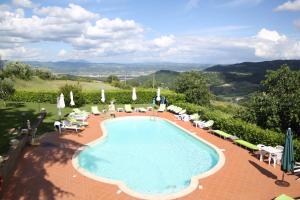 a swimming pool with chairs and umbrellas at Agriturismo Casale Le Burgne in Città di Castello