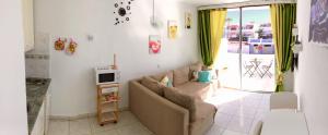 a living room with a couch and a tv at Apartamento privado con piscina in Costa Del Silencio