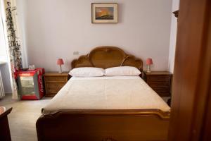 アルバにあるLe camere di Gioのベッドルーム1室(大型ベッド1台、ナイトスタンド2台付)
