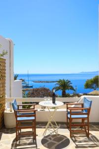 eine Terrasse mit einem Tisch, Stühlen und Meerblick in der Unterkunft Filoxenia by Grispos Villas in Schinoussa