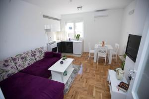 - un salon avec un canapé violet et une table dans l'établissement Apartment Marko, à Trebinje