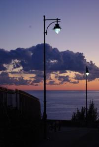 ジェノヴァにあるMiraVillaの夕日の海の前の二つの街灯