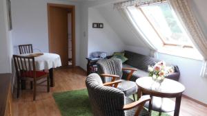 a living room with a couch and chairs and a table at Ferienwohnung mit Panoramablick in Kirchberg