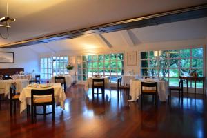 a dining room with white tables and chairs and windows at Locanda Dell'Angelo in Ameglia