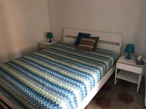 een slaapkamer met een bed met twee lampen erop bij Appartamenti La Quiete in Mele