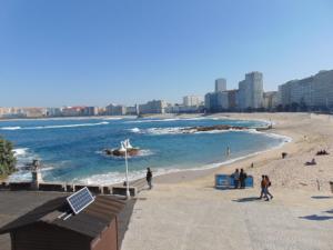 ア・コルーニャにあるApartamento Riazor Coruñaの砂浜と海の上の人々と一緒に楽しめる海岸