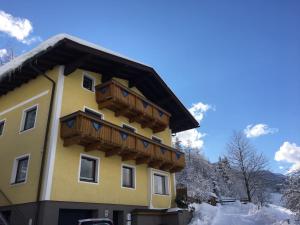 a yellow building with wooden balconies on it at Ferienhaus Karin in Bruck an der Großglocknerstraße