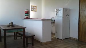 uma cozinha com um frigorífico branco e uma mesa em Apt Penedo em Penedo