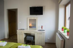 a room with a desk with a mirror and a tv at Pokoje Staromiejski in Uniejow