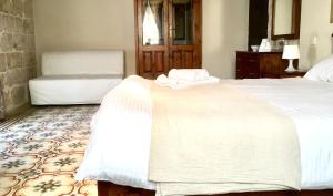 a bedroom with two beds and a chair at Xemx in Qala