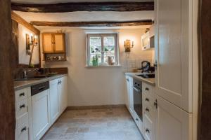 a kitchen with white cabinets and a window at Fachwerkhaus in Wolfhagen