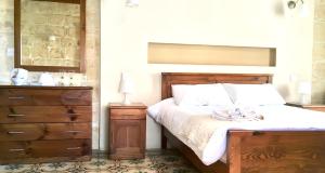 a bedroom with a large bed with a dresser and a bed sidx sidx sidx at Xemx in Qala