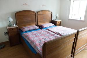- une chambre avec un grand lit en bois et 2 oreillers dans l'établissement Fachwerkhaus, à Wolfhagen