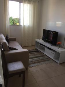 sala de estar con sofá y TV de pantalla plana en Spazio Solarium - Apartamento, en Lauro de Freitas